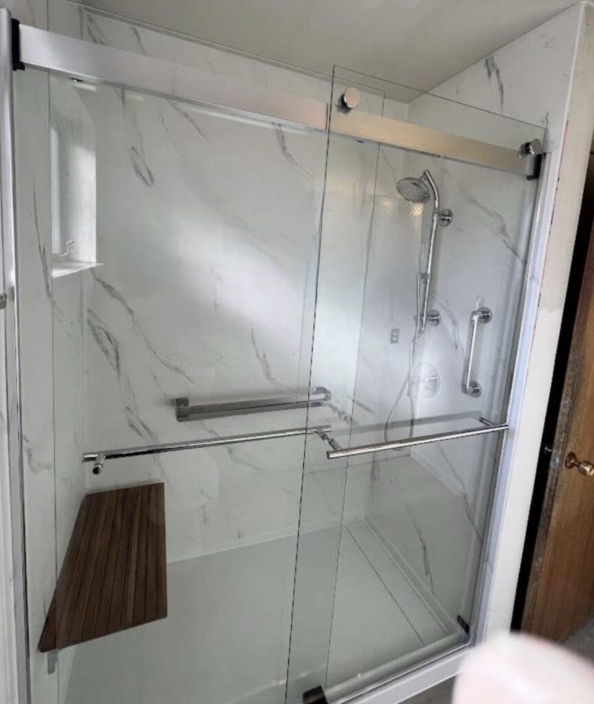 Pearl stone silhouette shower remodel with grab bars, shower bench, and adjustable shower head in Thornton Colorado