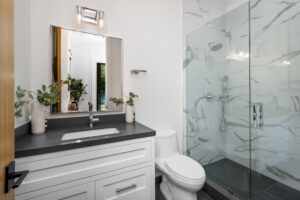 A white toilet, walk-in shower, and bathtub in a complete bathroom remodel