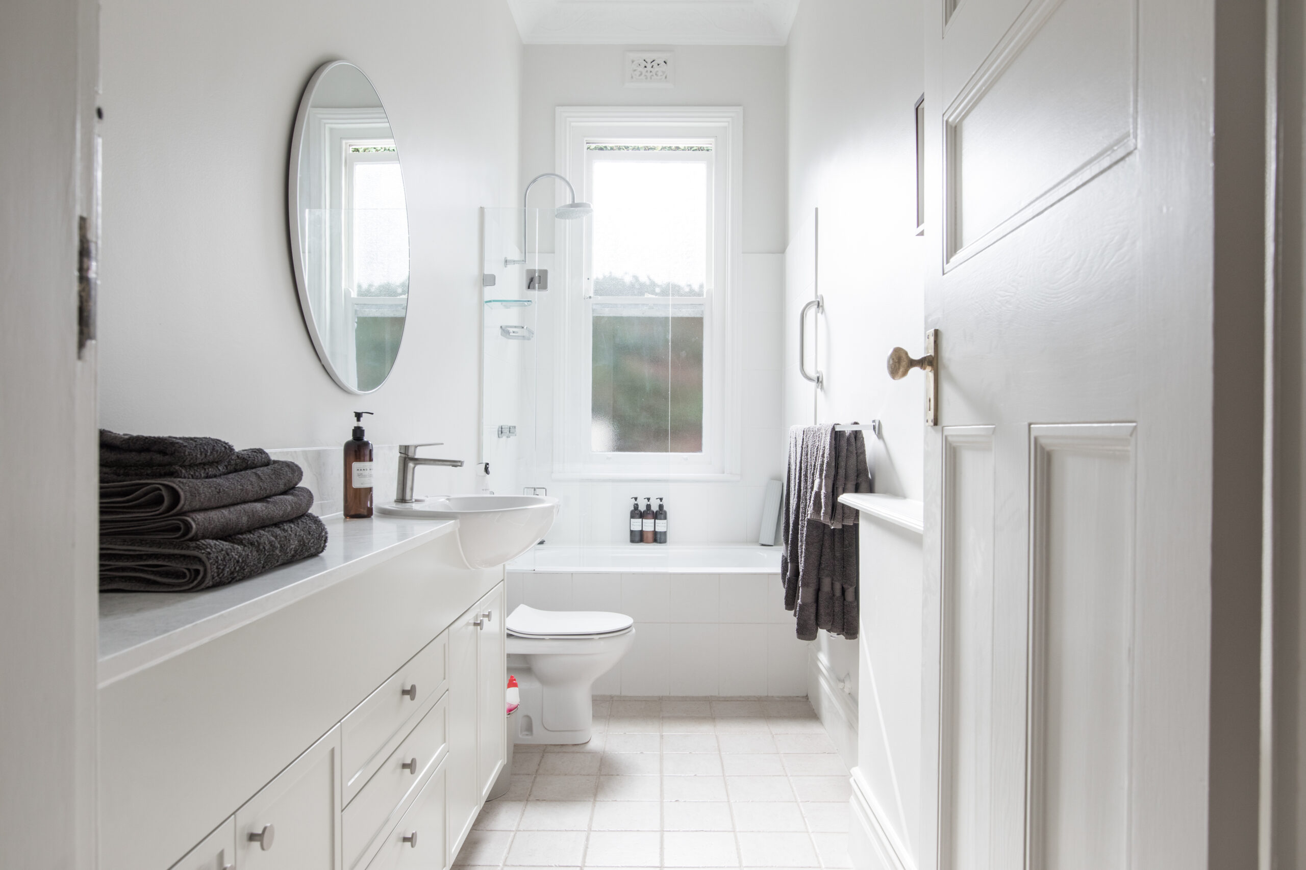 Bathroom transformation with deep soaking tub, toilet, vanity, and mirrors