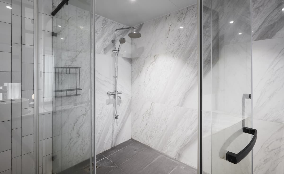 tub to shower conversion in Denver with solid surface walls and glass doors